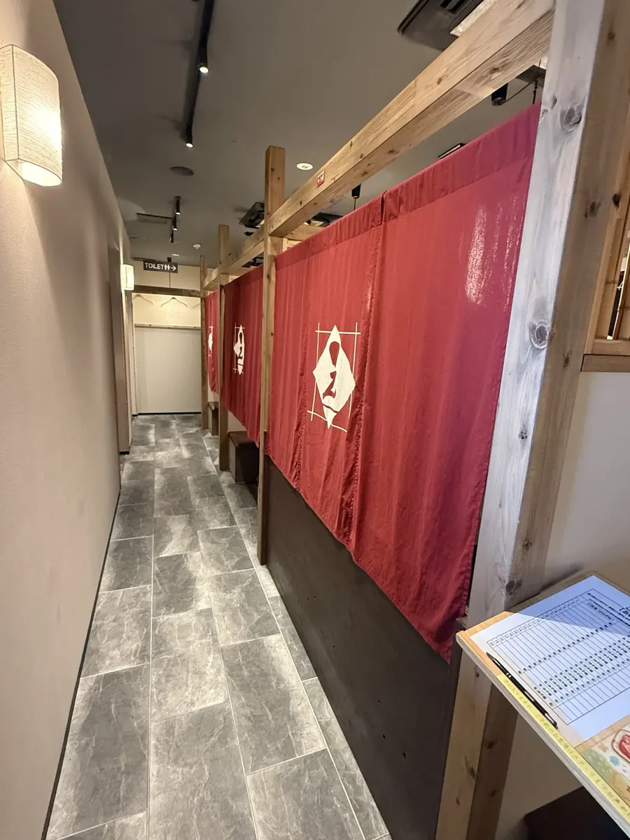 入口から見た赤い暖簾の店内通路